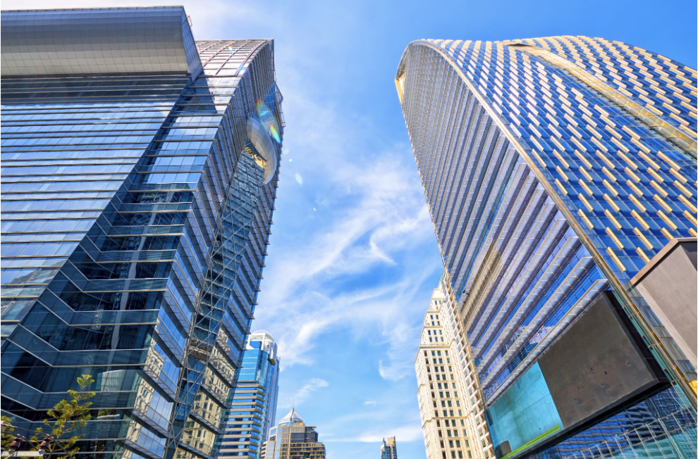 Modern glass commercial office buildings in an urban business district representing commercial real estate valuation and pricing.